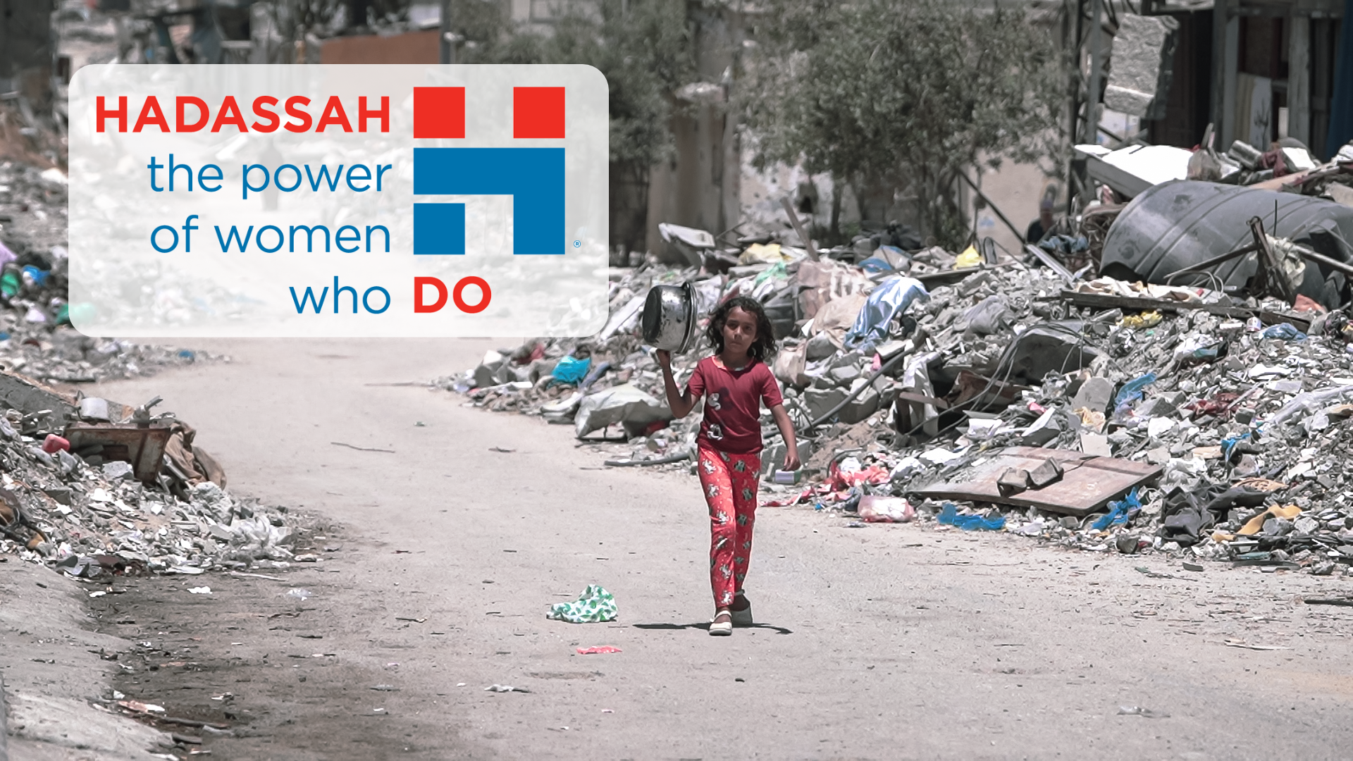 palestinian girl walking through rubble with hadassah logo